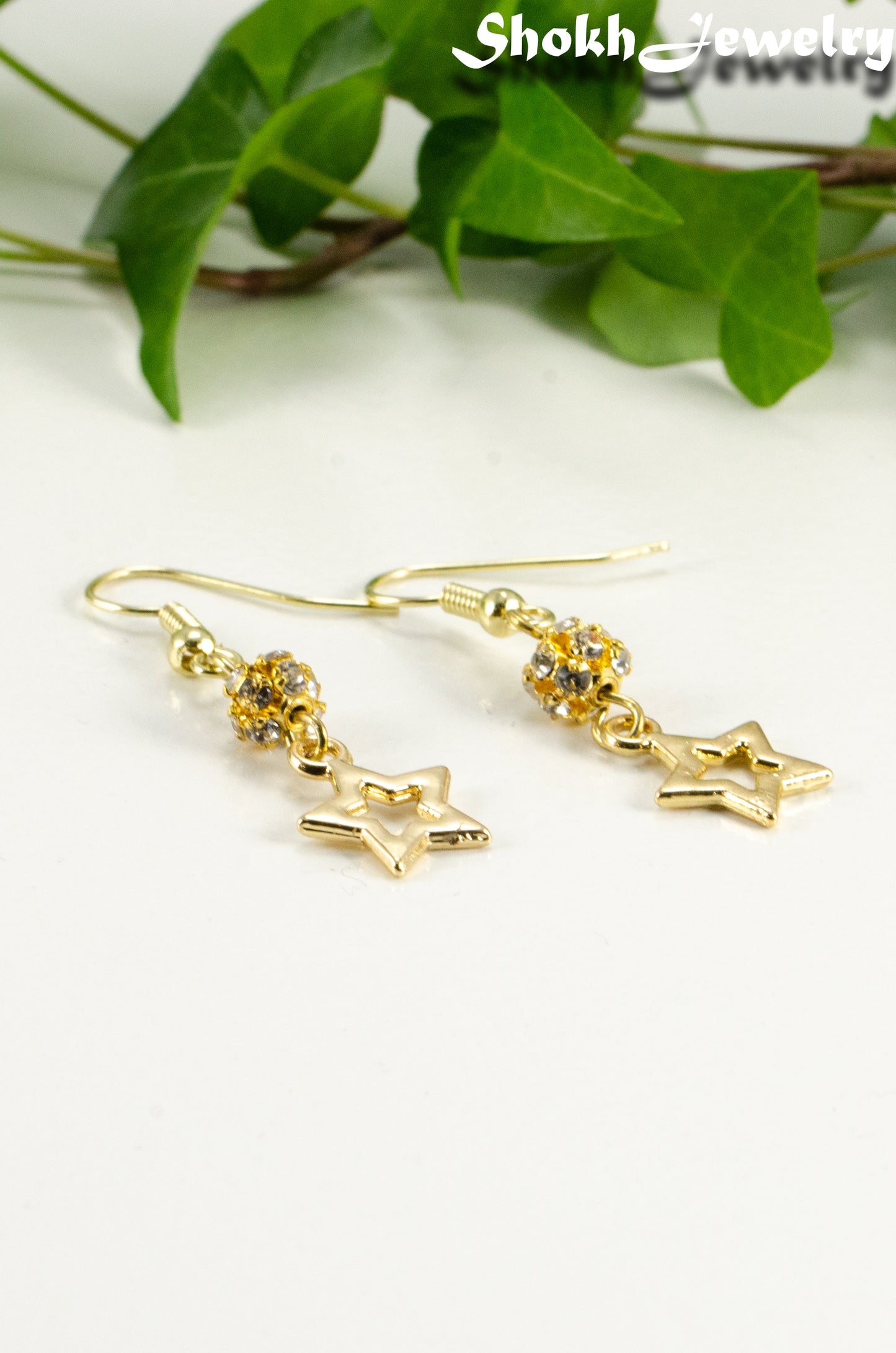 Close up of Sparkly Rhinestone and Gold Star Earrings.