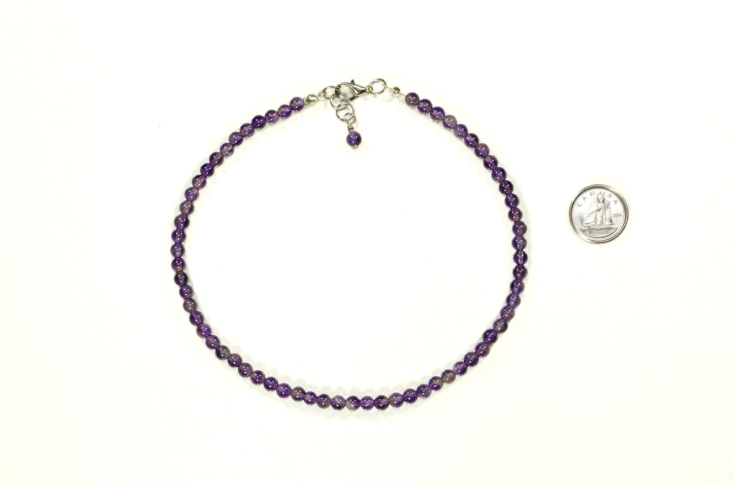 4mm Amethyst Crystal Choker Necklace beside a dime.