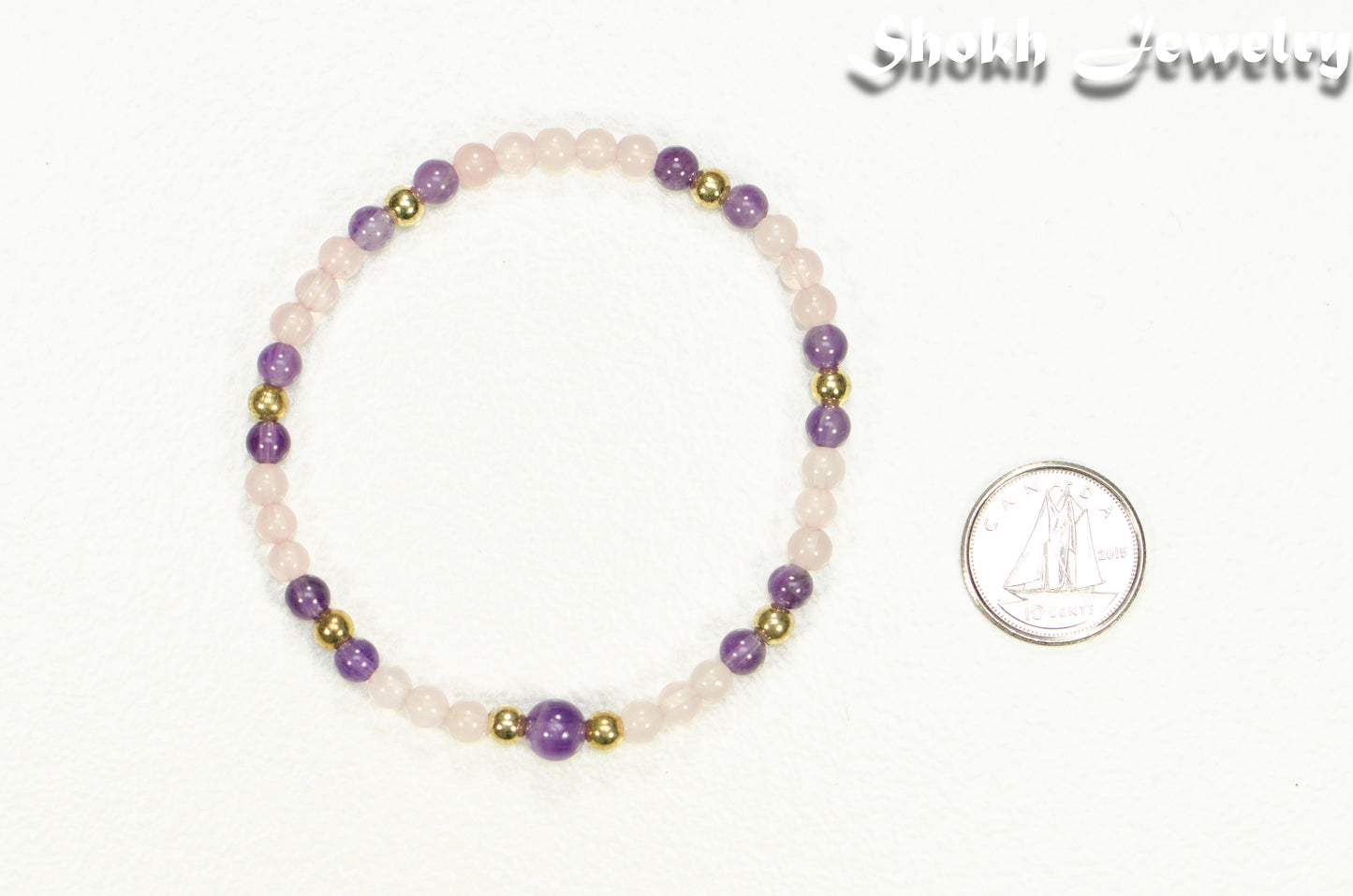 4mm Rose Quartz and Amethyst Bracelet beside a dime.