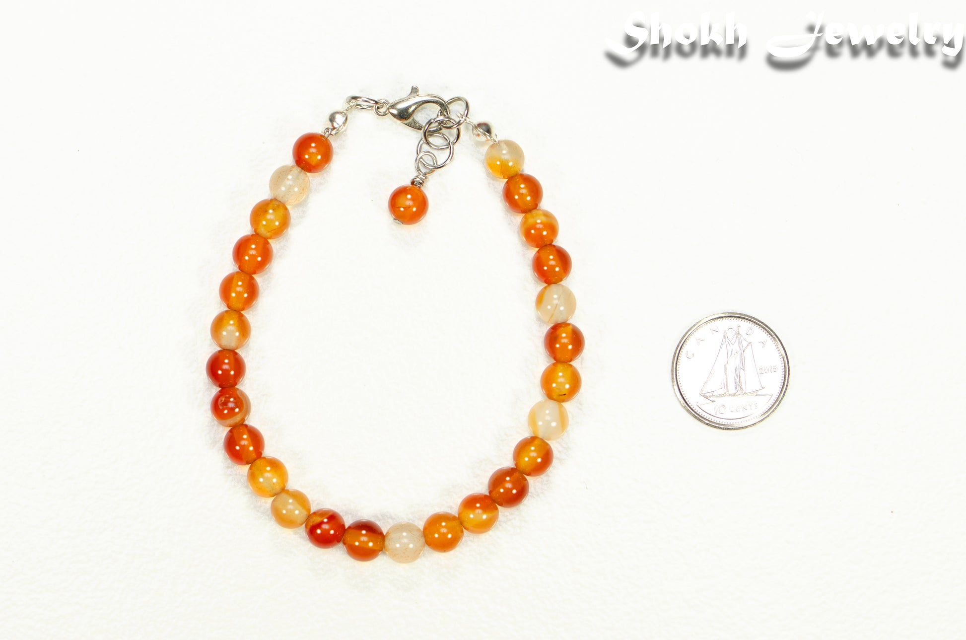 6mm Carnelian Crystal Bracelet beside a dime.