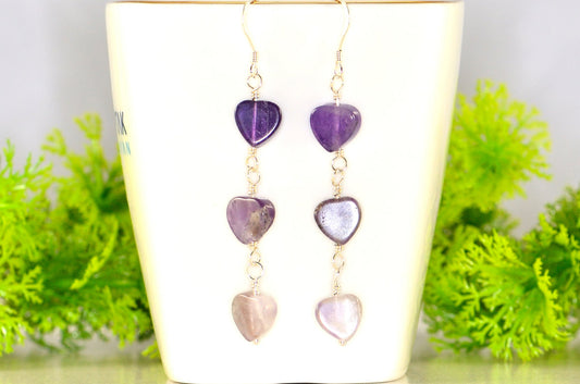 Natural Amethyst Heart Dangle Earrings displayed on a tea cup.