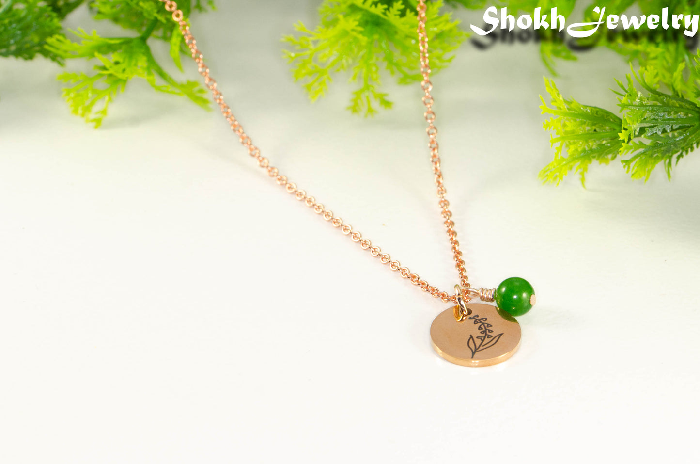 Close up of Rose Gold Plated May Birth Flower Necklace with Emerald Birthstone Pendant.