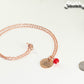 Rose Gold Plated July Birth Flower Necklace with Red Ruby Birthstone Pendant beside a dime.