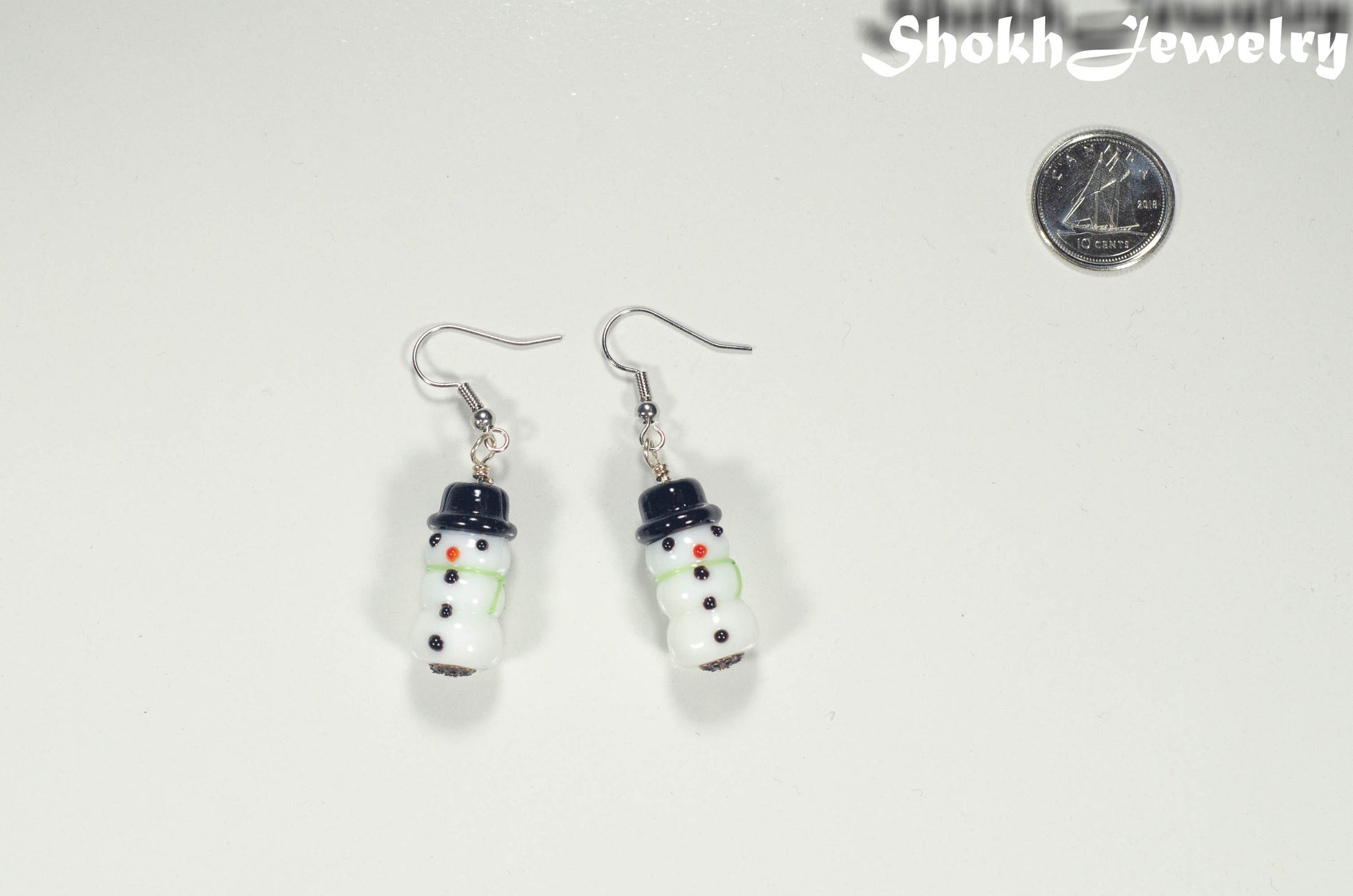 Snowman Glass Bead Earrings beside a dime.