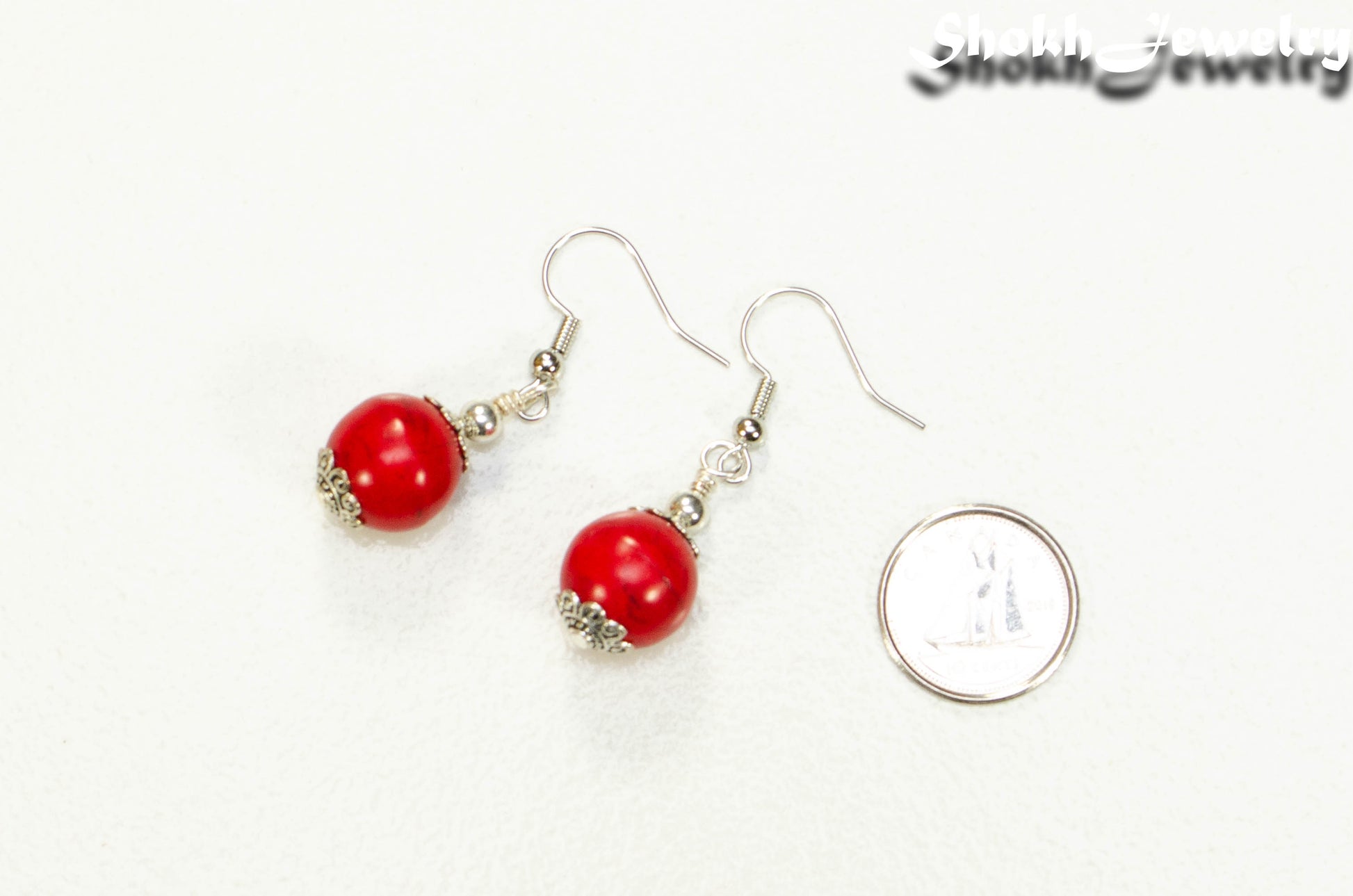 12mm Red Howlite Dangle Earrings beside a dime.