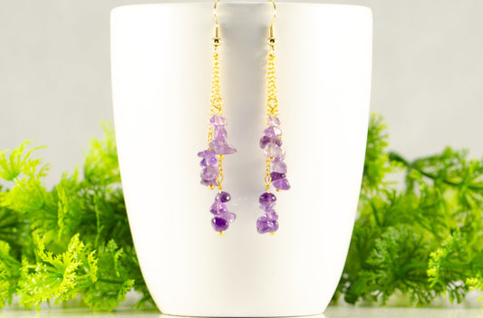 Long Gold Plated Chain and Amethyst Crystal Chip Earrings displayed on a coffee mug.