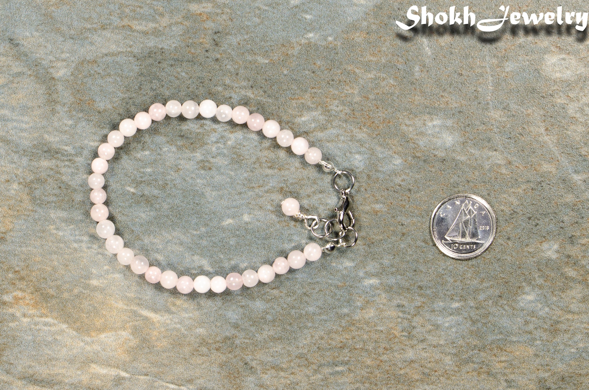 4mm Rose Quartz Bracelet with Clasp beside a dime.