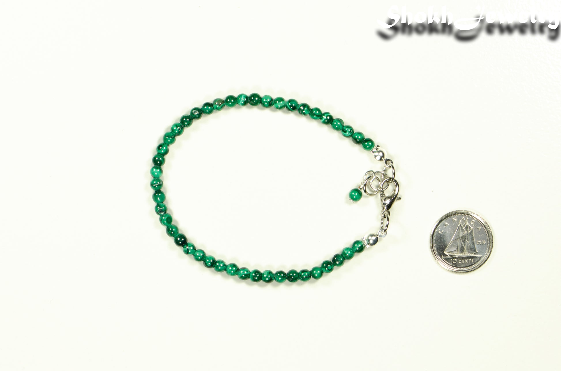 3mm Natural Malachite Bracelet with Clasp beside a dime.
