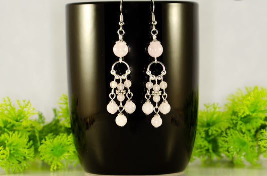 Statement Rose Quartz Chandelier Earrings displayed on a coffee mug.