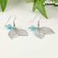 Close up of Filigree Leaf Charm and Aqua Blue Glass Crystal Earrings.