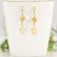 Sparkly Rhinestone and Gold Star Earrings displayed on a tea cup.
