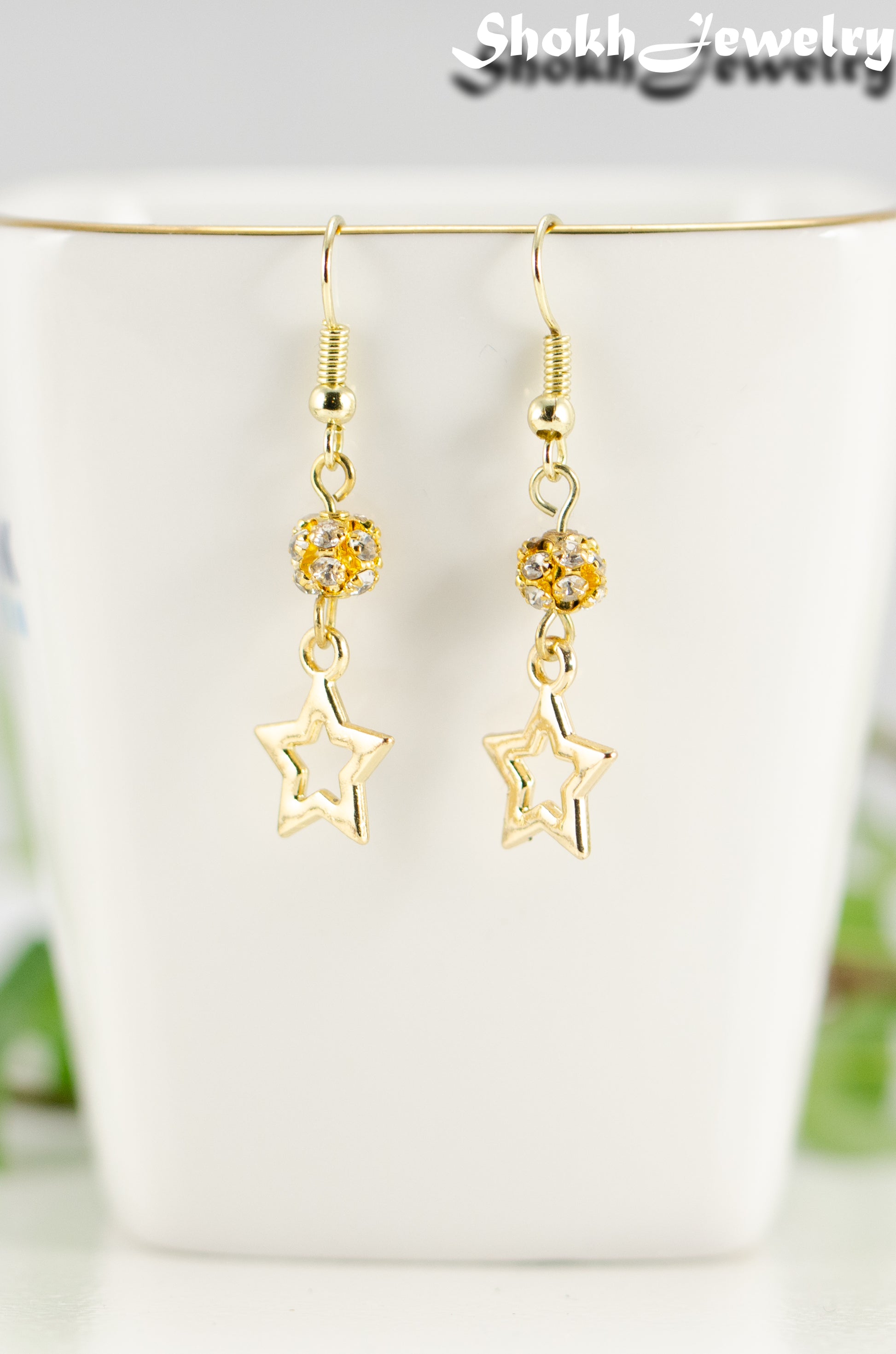Close up of Sparkly Rhinestone and Gold Star Earrings.