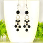 Statement Black Obsidian Chandelier Earrings displayed on a coffee mug.