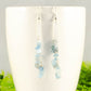 Long Silver Plated Chain and Aquamarine Crystal Chip Earrings on a mug